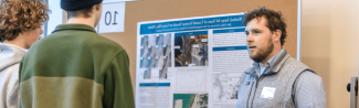 A UNE student presents his climate research to a group of conference attendees